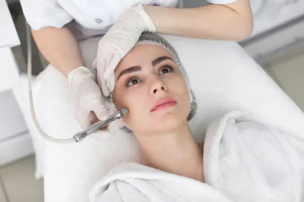 A woman receiving a microdermabrasion facial treatment at Melody Salon, focusing on skincare and relaxation.